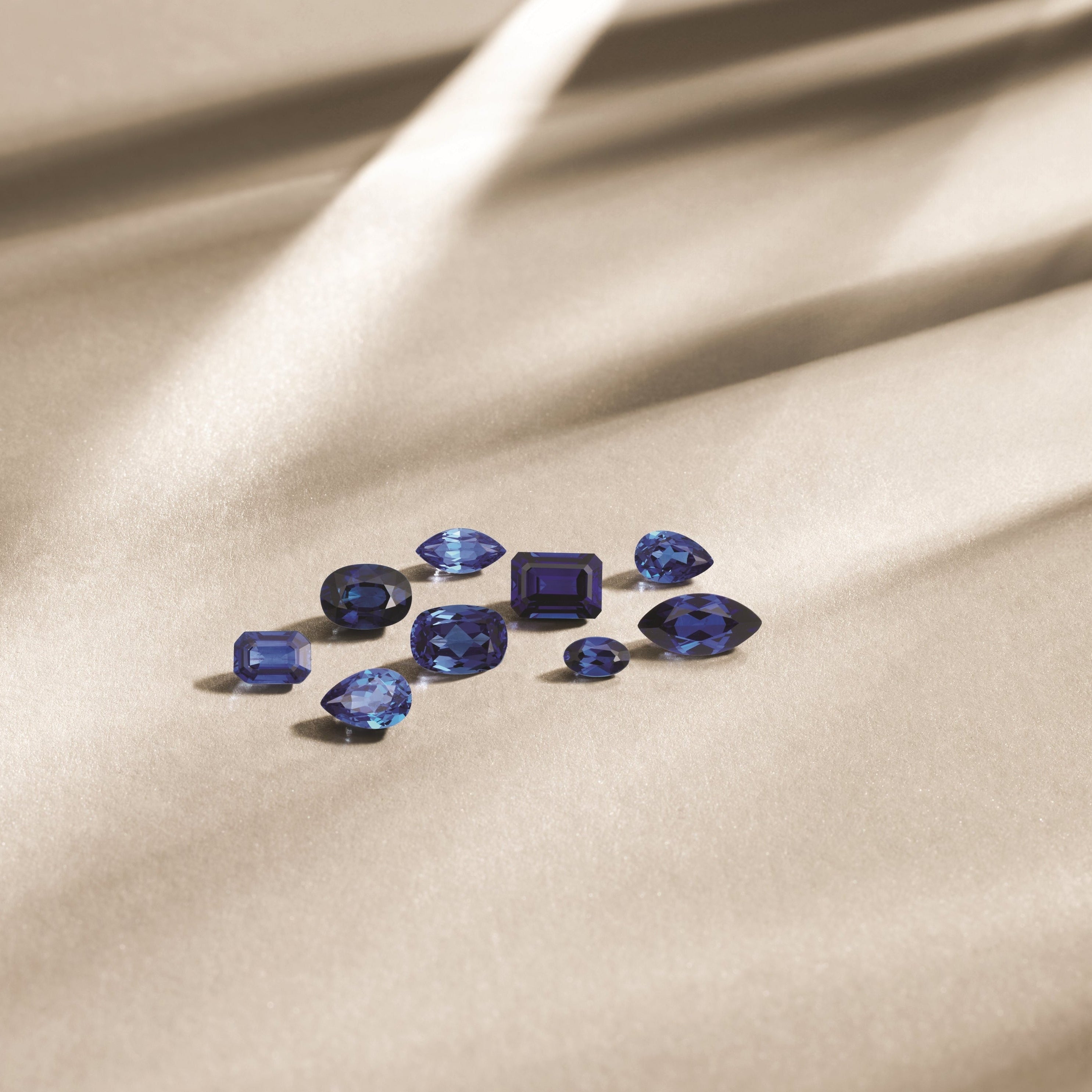 Loose blue sapphires in assorted shapes on satin