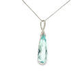 14K white gold pendant with an elongated pear-shaped pale blue aquamarine and diamond-accented sweeping bail.