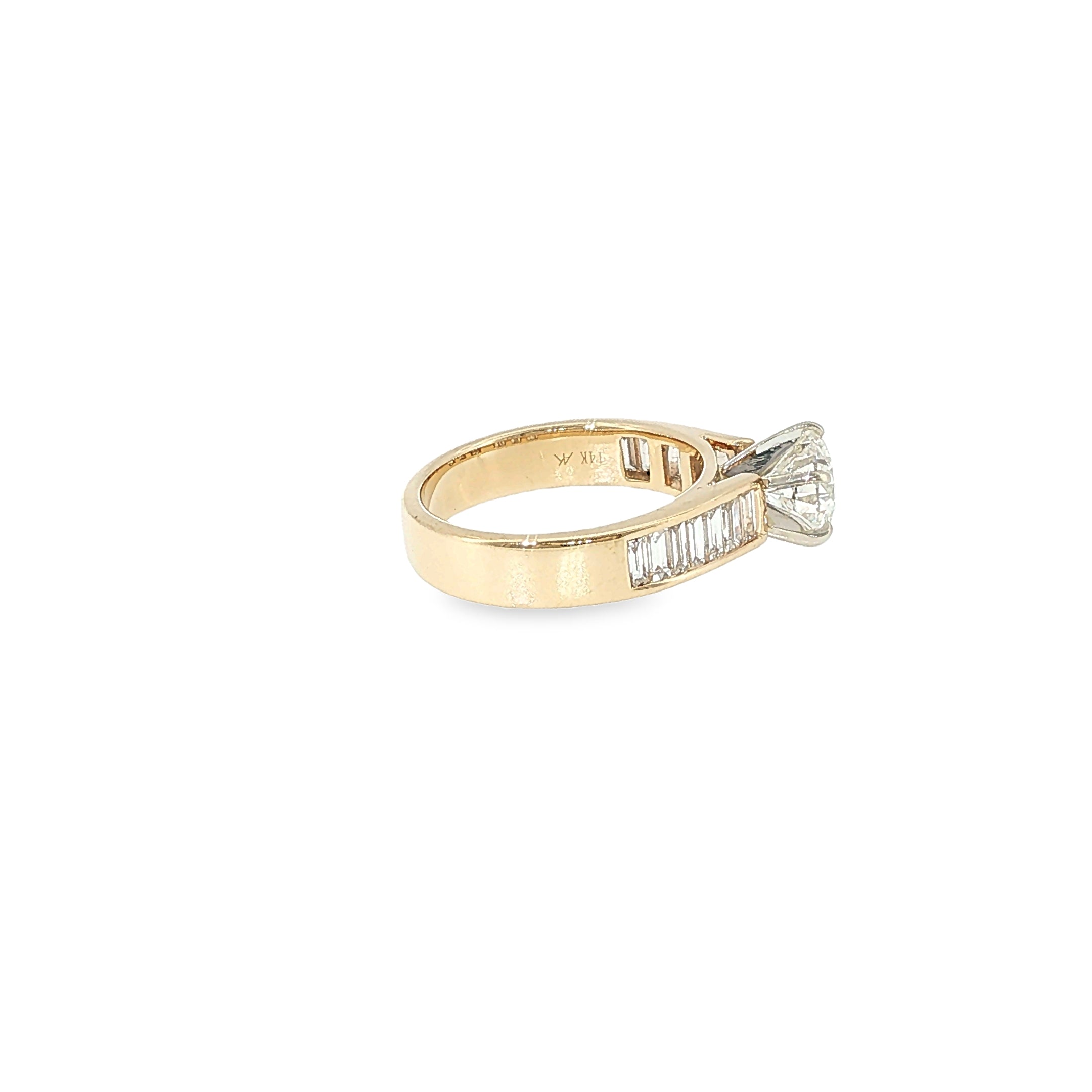 14K yellow gold engagement ring with a round brilliant diamond center and channel-set baguette diamond accents.