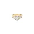 14K yellow gold engagement ring with a round brilliant diamond center and channel-set baguette diamond accents.