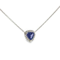 14K white gold necklace with a trillion-cut tanzanite surrounded by a diamond halo, shown angled to the left.