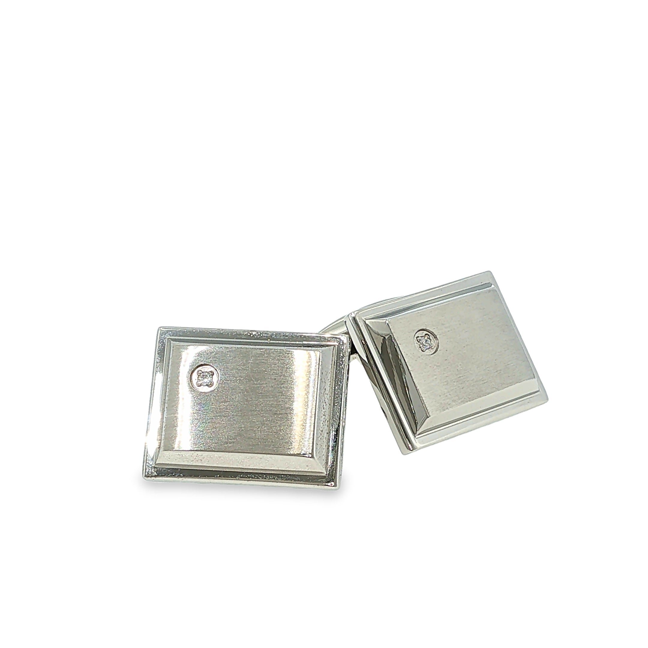 Brushed stainless steel rectangular cuff links with single cubic zirconia accents, shown angled to the left.