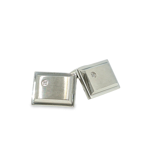 Brushed stainless steel rectangular cuff links with single cubic zirconia accents, shown angled to the left.