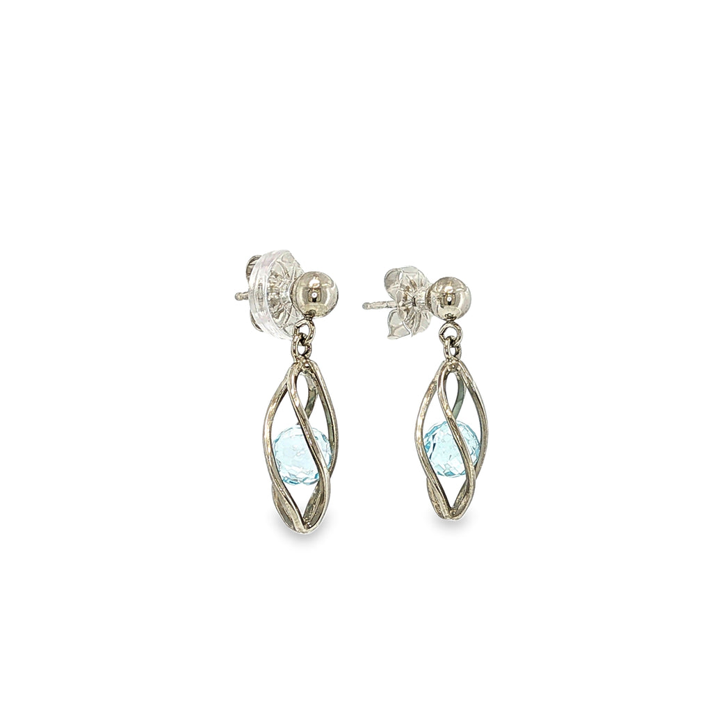 Sterling silver drop earrings with marquise blue topaz gemstones suspended inside open-cage designs.