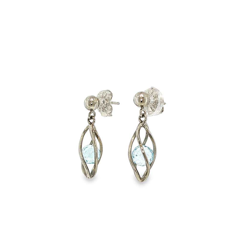 Sterling silver drop earrings with marquise blue topaz gemstones suspended inside open-cage designs.
