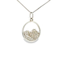 Sterling silver round pendant with an openwork mountain landscape and textured mountain peak design.