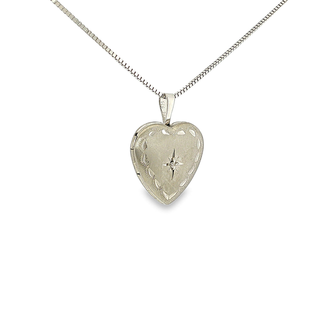 Satin-finished sterling silver heart locket with engraved detailing and a single diamond accent.