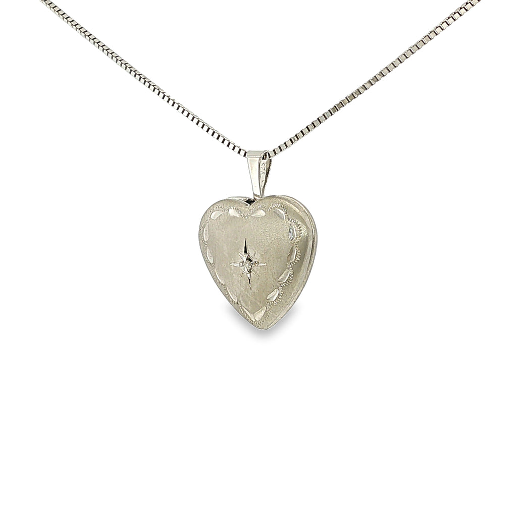 Satin-finished sterling silver heart locket with engraved detailing and a single diamond accent.