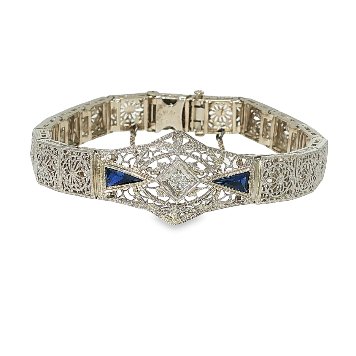 Art Deco white gold and platinum filigree bracelet with a round diamond and two triangular blue synthetic sapphires.