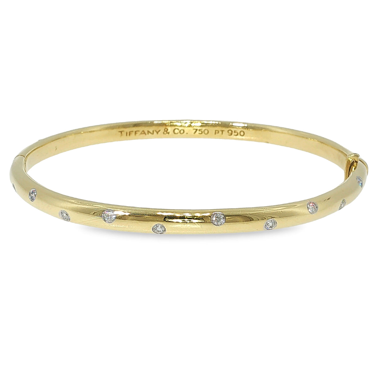 Tiffany & Co. 18K yellow gold and platinum bangle bracelet with scattered flush-set diamonds.