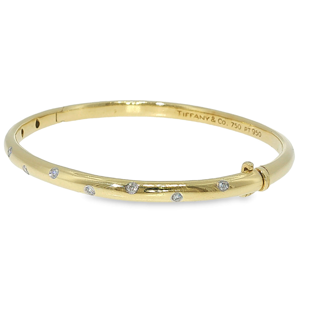 Tiffany & Co. 18K yellow gold and platinum bangle bracelet with scattered flush-set diamonds.