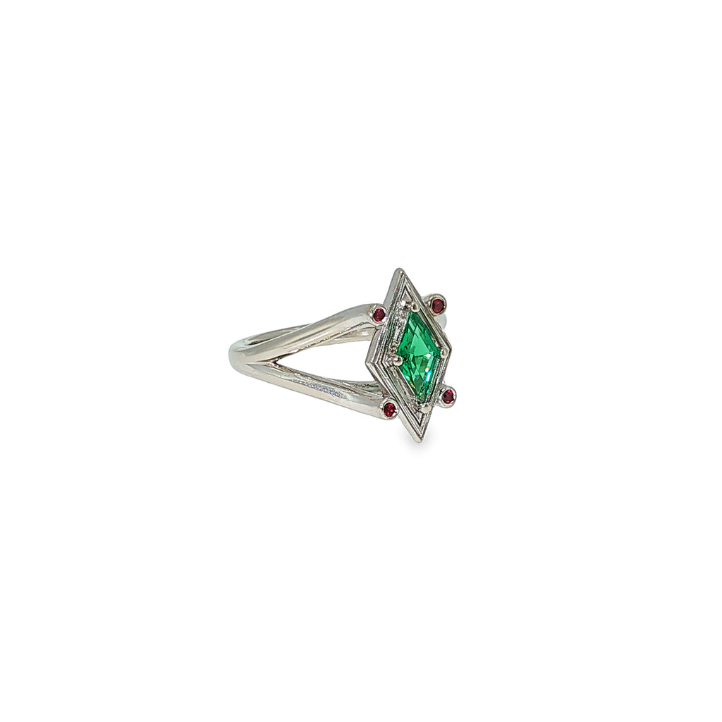 14K white gold geometric ring with a diamond-shaped lab-grown emerald and four small ruby accents.