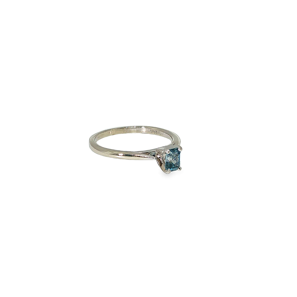14K white gold solitaire ring with a light blue emerald-cut sapphire in a four-prong setting.