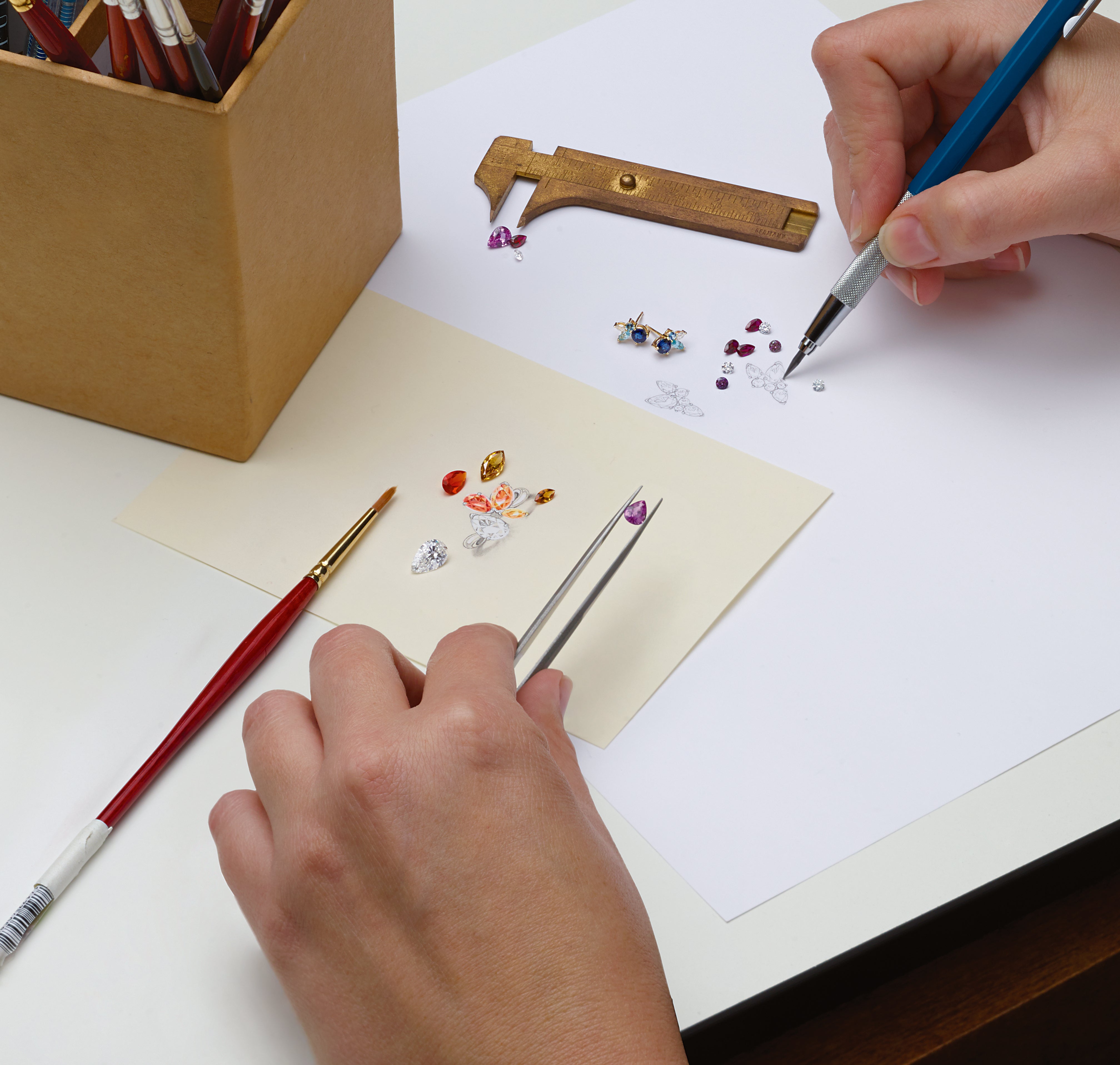 Jewelry designer working with loose gemstones and ring sketches