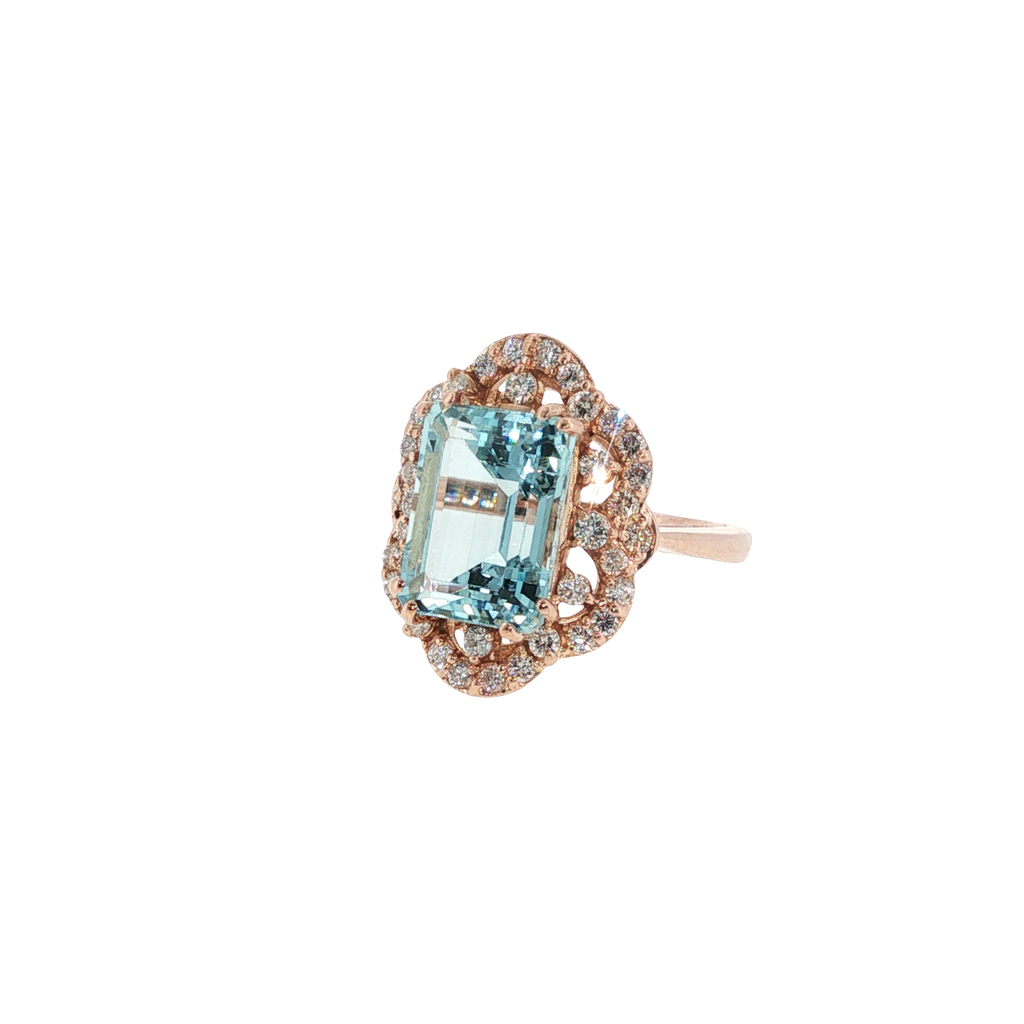 14K rose gold ring with an emerald-cut pale blue aquamarine surrounded by round diamond accents.