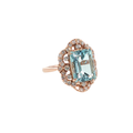 14K rose gold ring with an emerald-cut pale blue aquamarine surrounded by round diamond accents.