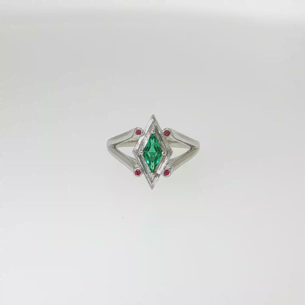14K white gold geometric ring with a diamond-shaped lab-grown emerald and four small ruby accents.