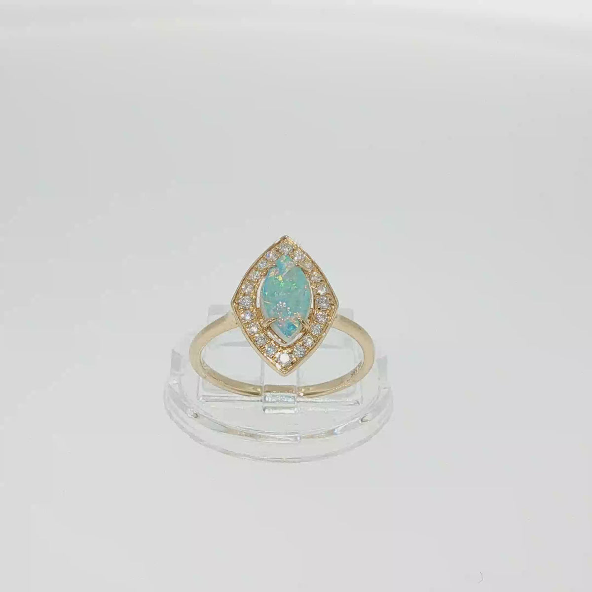 14K yellow gold ring with a marquise AAA opal surrounded by a diamond halo.