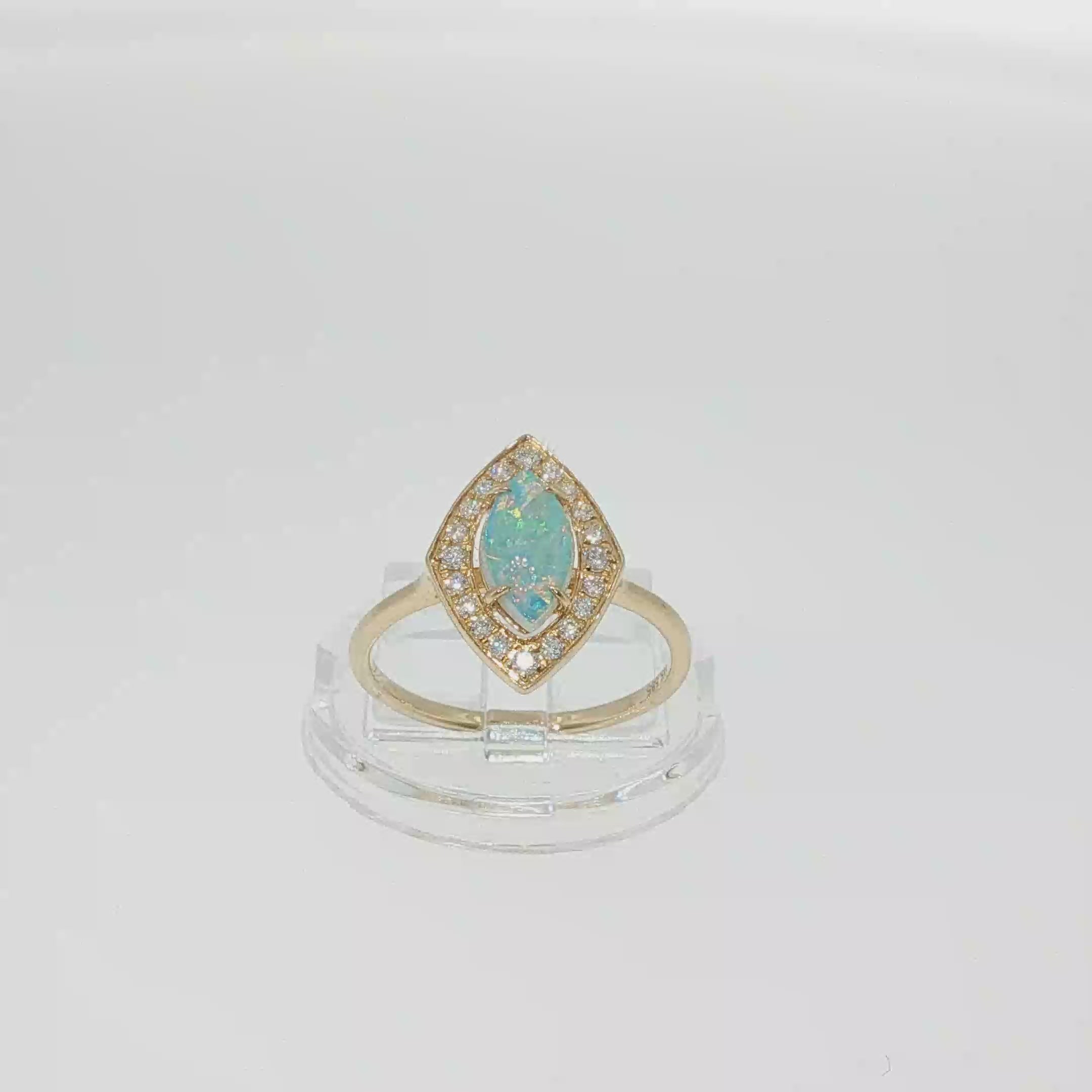 14K yellow gold ring with a marquise AAA opal surrounded by a diamond halo.