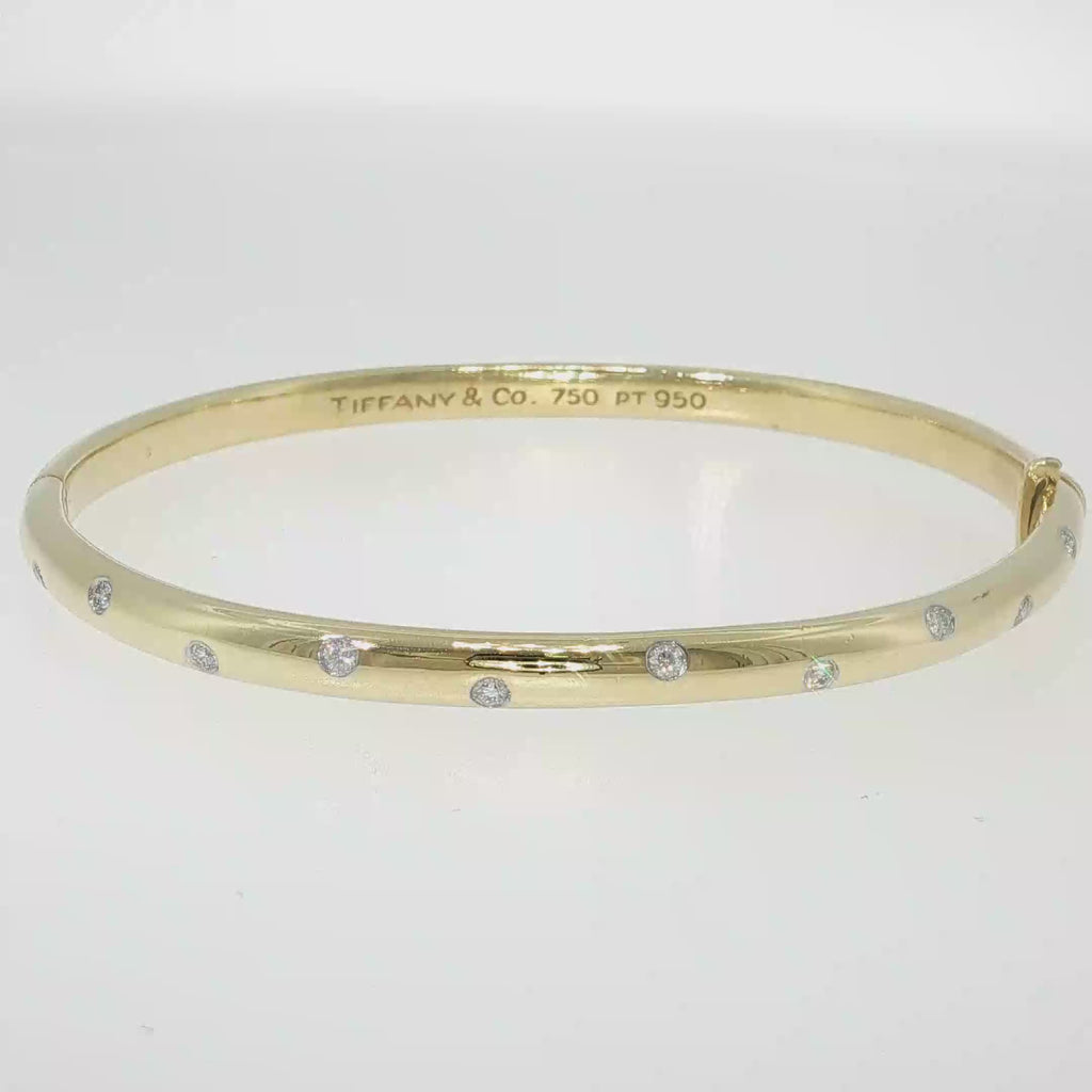 Tiffany & Co. 18K yellow gold and platinum bangle bracelet with scattered flush-set diamonds.