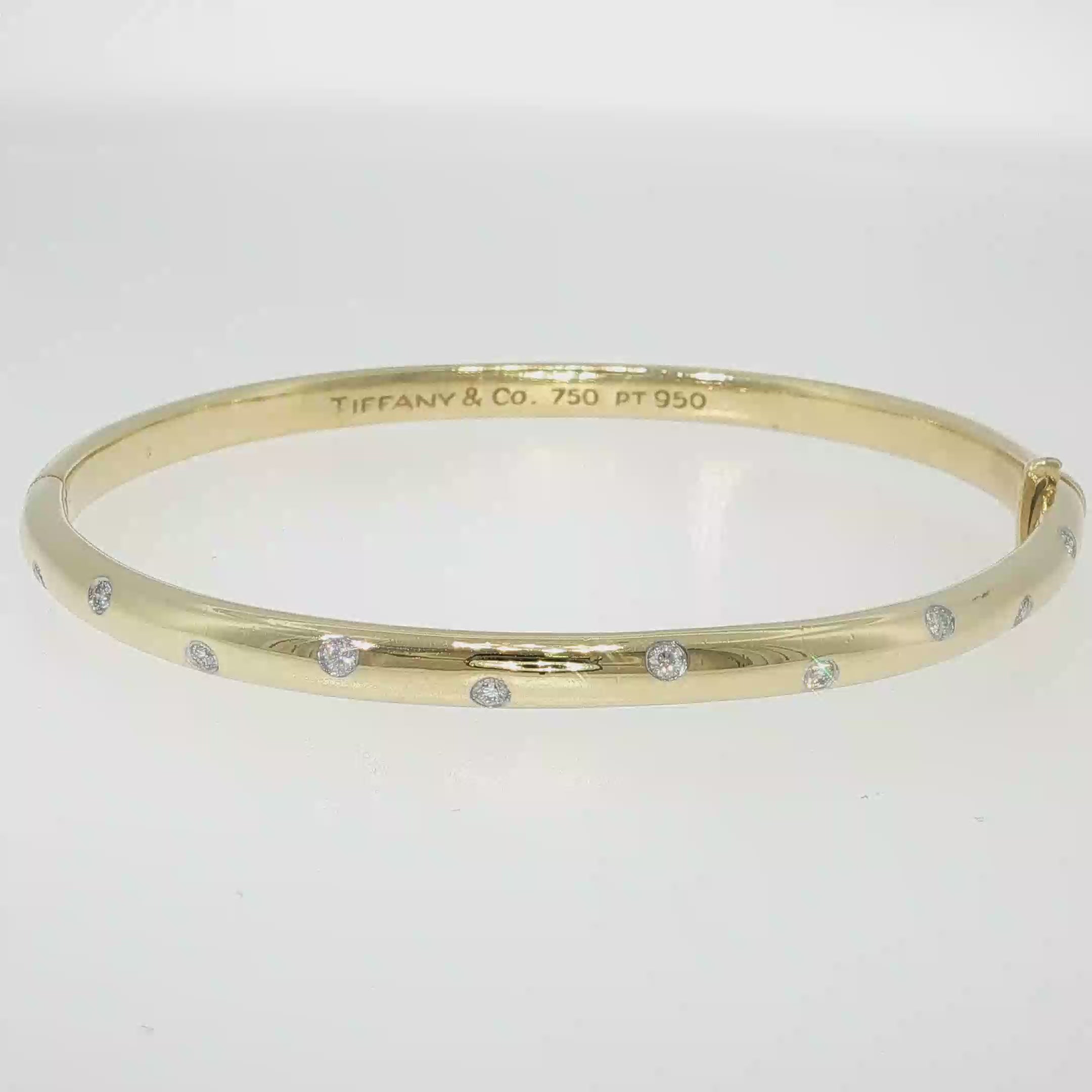 Tiffany & Co. 18K yellow gold and platinum bangle bracelet with scattered flush-set diamonds.