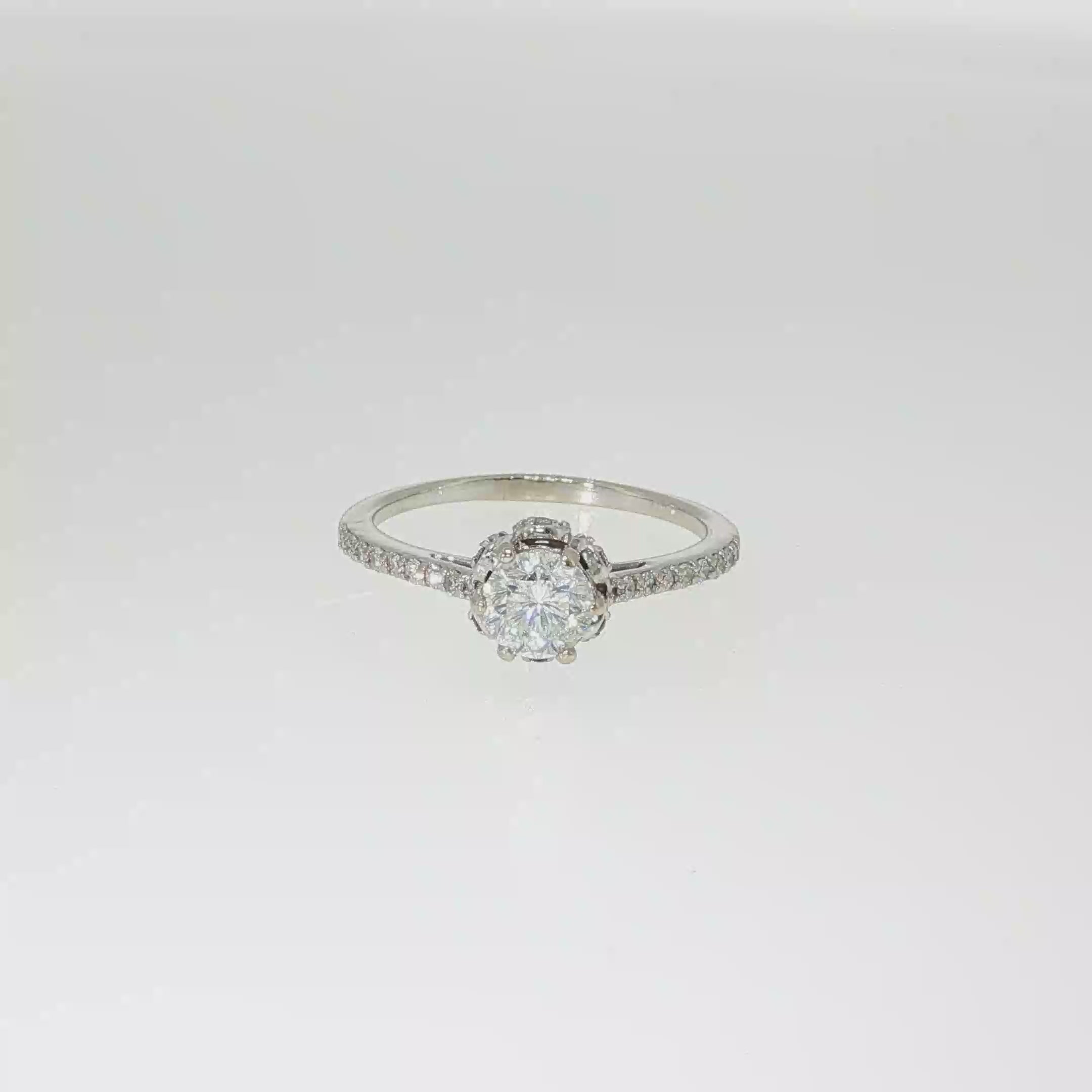 Round brilliant diamond engagement ring with a hidden halo and diamond-accented band in 14K white gold.