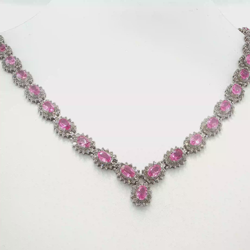 14K white gold pink sapphire and diamond necklace with oval pink sapphires, diamond halos, and a graduated center drop.