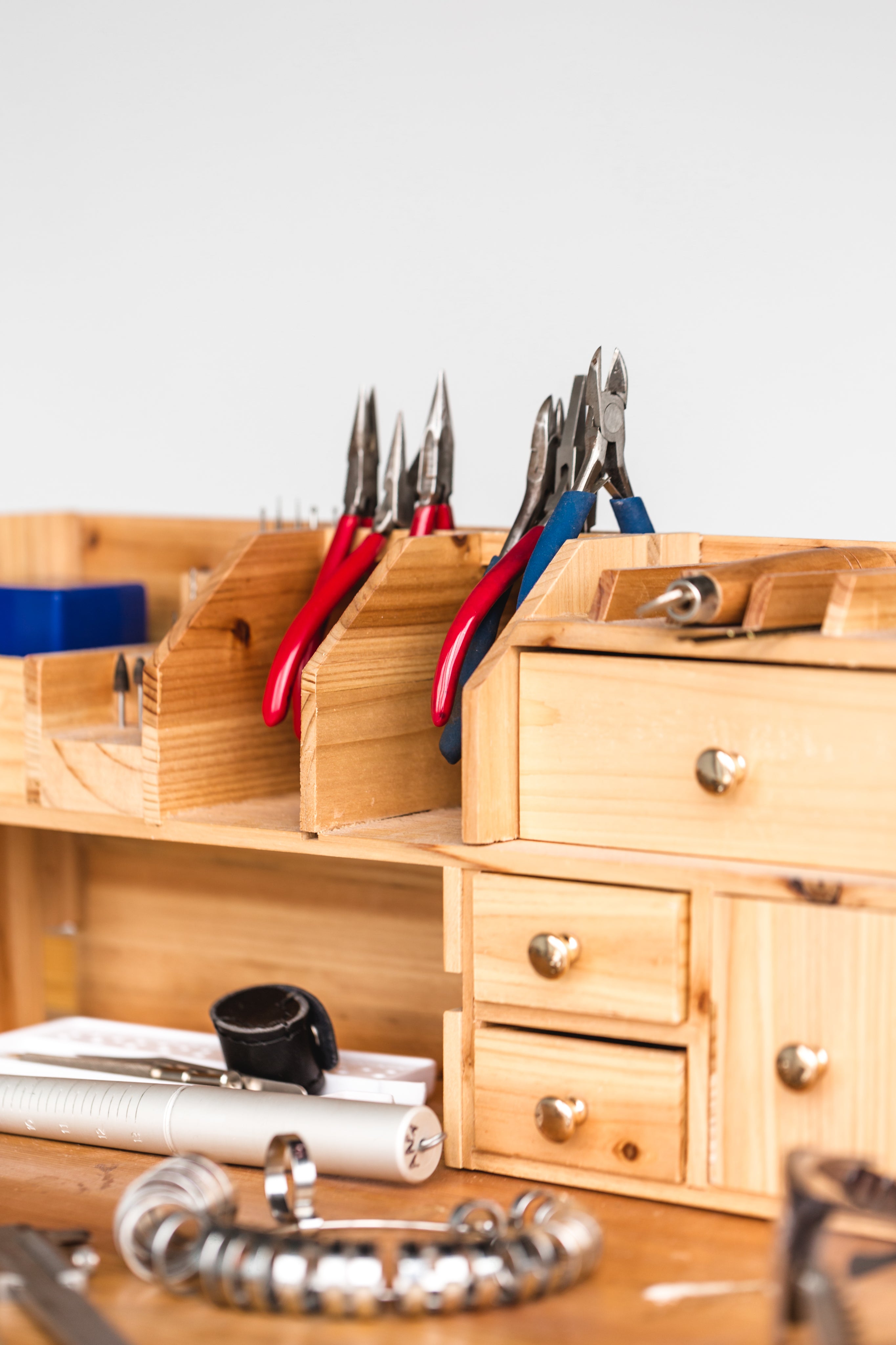 Jewelry repair tools arranged on a wooden workbench